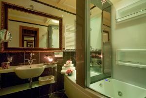 a bathroom with a tub, sink and mirror at Hotel Manfredi Suite In Rome in Rome