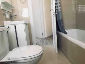 a bathroom with a white toilet and a bath tub at 2 BDR Nitza appartment with balkony in Netanya