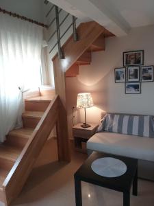 un piccolo soggiorno con scala e divano di Girni Gold Apartments,Petković a Olympiakí Aktí