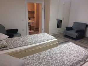 1 dormitorio con 2 camas, sofá y silla en Warm Studio en Sibiu