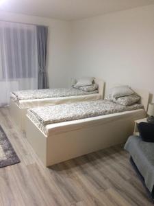 Duas camas sentadas num quarto com ainilinylinylinyl em Warm Studio em Sibiu