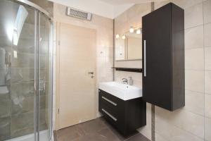 y baño con lavabo y ducha. en Apartments Smojver Stipe en Baška