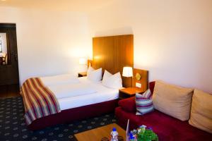 ein Hotelzimmer mit einem Bett und einem Sofa in der Unterkunft Gästehaus Rössler in Brannenburg