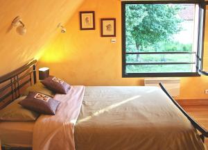 1 dormitorio con cama y ventana grande en Chambre d'hôtes La Dentalie en Rouffignac Saint-Cernin