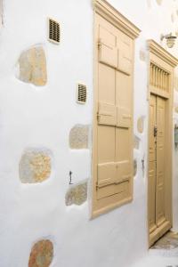 an open door on a white wall with rocks at Kleio House in Astypalaia Town