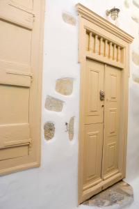 a door in a white wall next to a doorway at Kleio House in Astypalaia Town