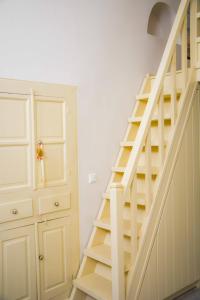 a wooden staircase in a room with a closet at Kleio House in Astypalaia Town