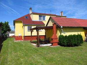 una casa gialla con tetto rosso e patio di Holiday Home U Čápů a Lomnice nad Lužnicí