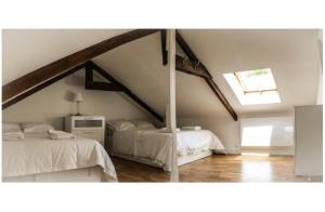 1 dormitorio en el ático con 2 camas y tragaluz en The Cider House: charming 2 bedroom cottage, en Mellac
