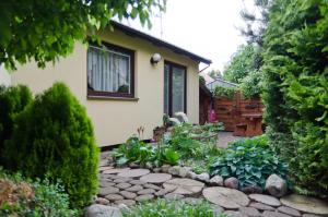 a garden with a stone walkway in front of a house at Domek Letniskowy Pucka in Mieroszyno