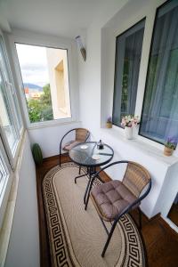a room with two chairs and a table and two windows at ROMANTIK APARTMENTS in Câmpulung Moldovenesc +10 photos