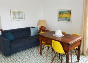 a living room with a couch and a table with yellow chairs at Luna Caprese Guest House in Anacapri