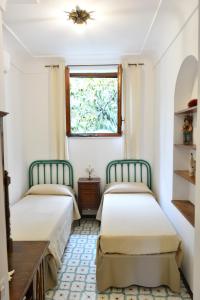 two beds in a room with a window at Luna Caprese Guest House in Anacapri