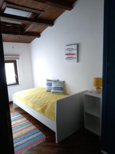 1 dormitorio con 1 cama con sábanas amarillas y ventana en Casa PAN (Percorso Arabo Normanno) en Palermo