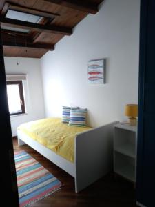 - une chambre avec un lit doté de draps jaunes et une fenêtre dans l'établissement Casa PAN (Percorso Arabo Normanno), à Palerme