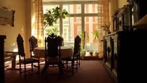 a dining room with a table and chairs and a window at Altstadt Pension Hafenblick in Stralsund