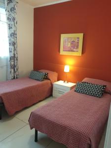 2 camas en una habitación con paredes rojas en B&B Circuit, en Borgo San Lorenzo