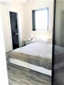 een slaapkamer met een groot bed en een raam bij 2 BDR Nitza appartment with balkony in Netanya