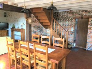 a dining room with a wooden table and chairs at Gite de Sologne "les galoches" in Dhuizon