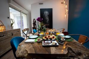 a wooden table with food on it in a dining room at La Parenthèse des Capucins - Maison d'hôtes Bordeaux in Bordeaux +61 photos