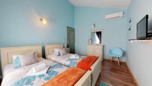 two beds in a room with blue walls at Villa Melody Novalja in Novalja