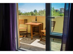 een balkon met een tafel met wijnglazen erop bij Olive Tree Apartments in Split