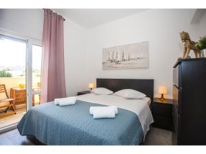 een slaapkamer met een bed met twee handdoeken erop bij Olive Tree Apartments in Split