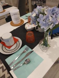 a table topped with a vase of blue flowers and a cup at B&B CELESTE in Bedonia