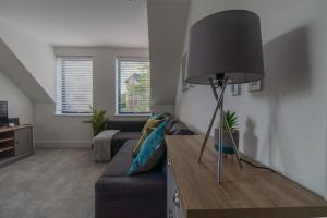 a living room with a couch and a black lamp at Town Centre Lodge in Huntingdon