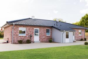 una casa de ladrillo rojo con garaje en Gästehaus hygge, en Nübbel