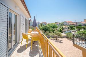 a balcony with a table and chairs and an umbrella at Apartments Klavdija in Vodice