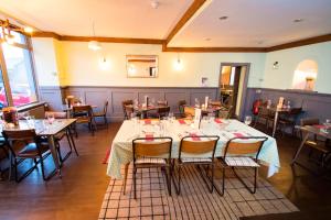 um restaurante com mesas e cadeiras num quarto em Nik The Greek em Burry Port