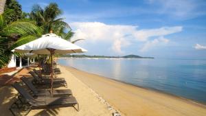 uma praia com cadeiras e um guarda-sol e o oceano em Paradise Beach Resort, Koh Samui - SHA Extra Plus em Mae Nam