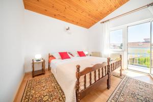 a bedroom with a bed and a large window at Apartments Klavdija in Vodice