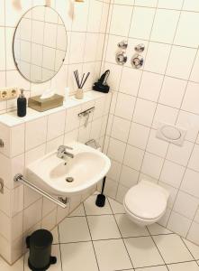 ein weißes Badezimmer mit Waschbecken und Toilette in der Unterkunft Ferienwohnungen mit Terrasse in Zwingernähe - Hilger Rentals in Dresden + 28 Fotos
