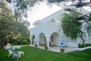 a white building with chairs and tables in a yard at Villa"Dar Janna" in Hammamet