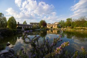 einen Teich in einem Garten mit Häusern und Blumen in der Unterkunft SkyLine apartments in Mostar