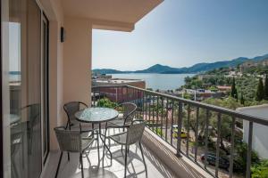 a balcony with a table and chairs and a view of the water at Guest House Pržno Bay in Sveti Stefan