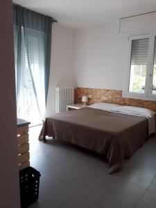a bedroom with a large bed and two windows at R&B Manga Rosas in Lido di Dante