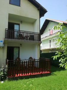 a house with a balcony and chairs in the yard at Holiday Home Iman in Sarajevo