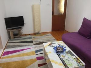 a living room with a purple couch and a tv at Holiday Home Iman in Sarajevo