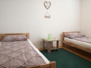 a bedroom with two beds and a table with a clock at Holiday Home Iman in Sarajevo