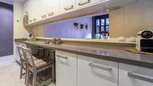a kitchen with a counter with a sink and a chair at La Morella del Carmen in Valencia