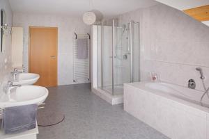 Un baño con bañera, lavabo y ducha. en Apartment 4, en Gottmadingen 8 fotos más