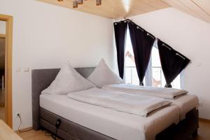1 cama con cortinas negras en una habitación con ventana en Apartment 4, en Gottmadingen