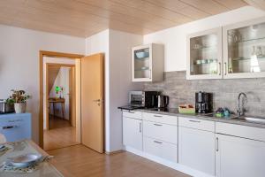 Una cocina con gabinetes blancos y encimera. en Apartment 4, en Gottmadingen