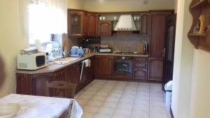 a kitchen with wooden cabinets and a table with a microwave at Marco in Świętoszówka