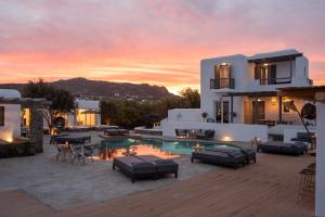 une villa avec une piscine en face d'un coucher de soleil dans l'établissement Olive Mykonos Villas, à Ano Mera