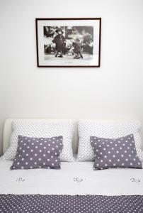 a bed with polka dot pillows and a picture on the wall at Old Town Apartment Split in Split