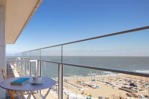 a balcony with a table and a view of the beach at knokkeappart Studio 2 pers in Knokke-Heist